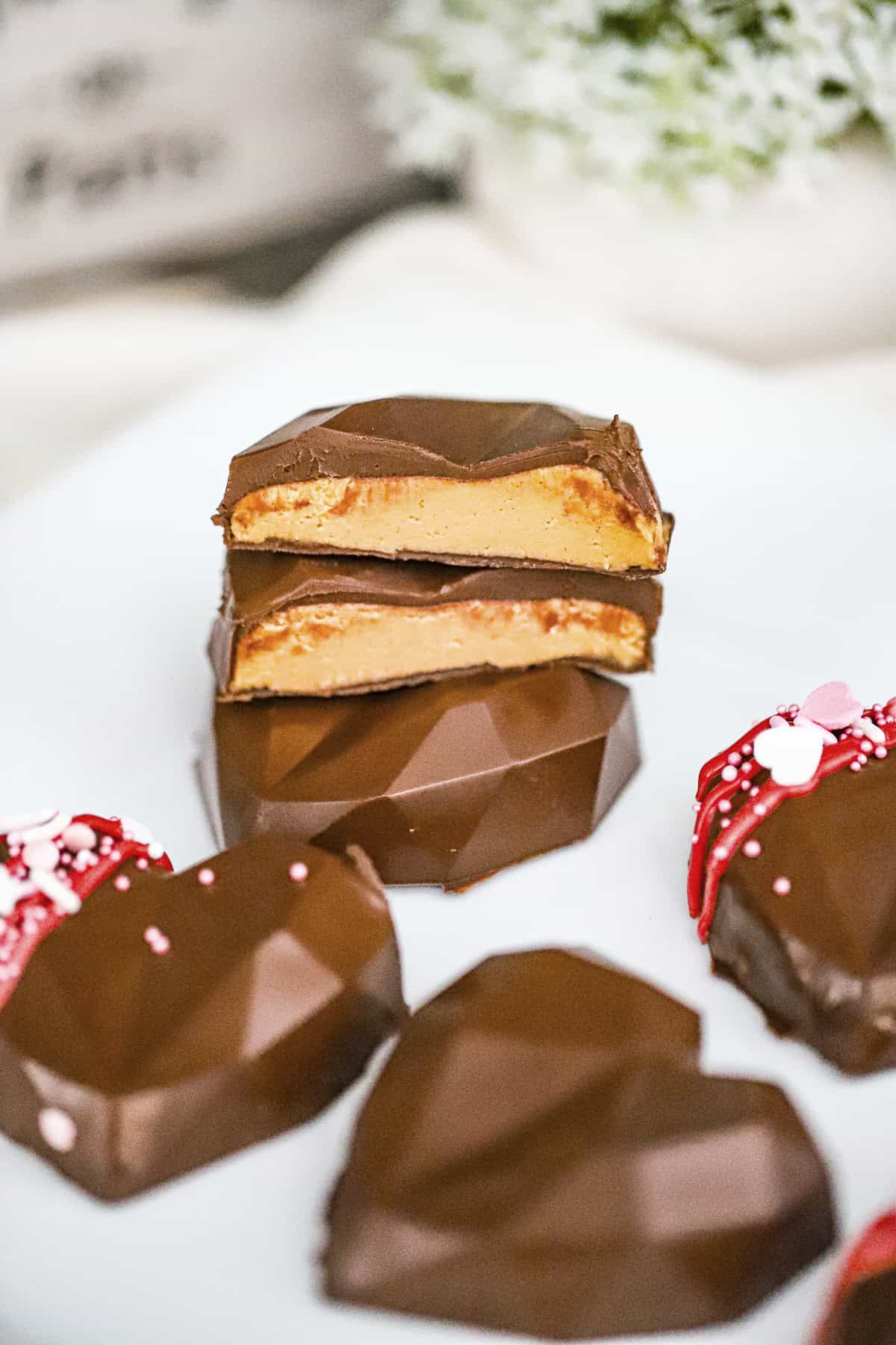 Copycat Reese's peanut butter hearts in geometric heart shapes with glossy chocolate coating