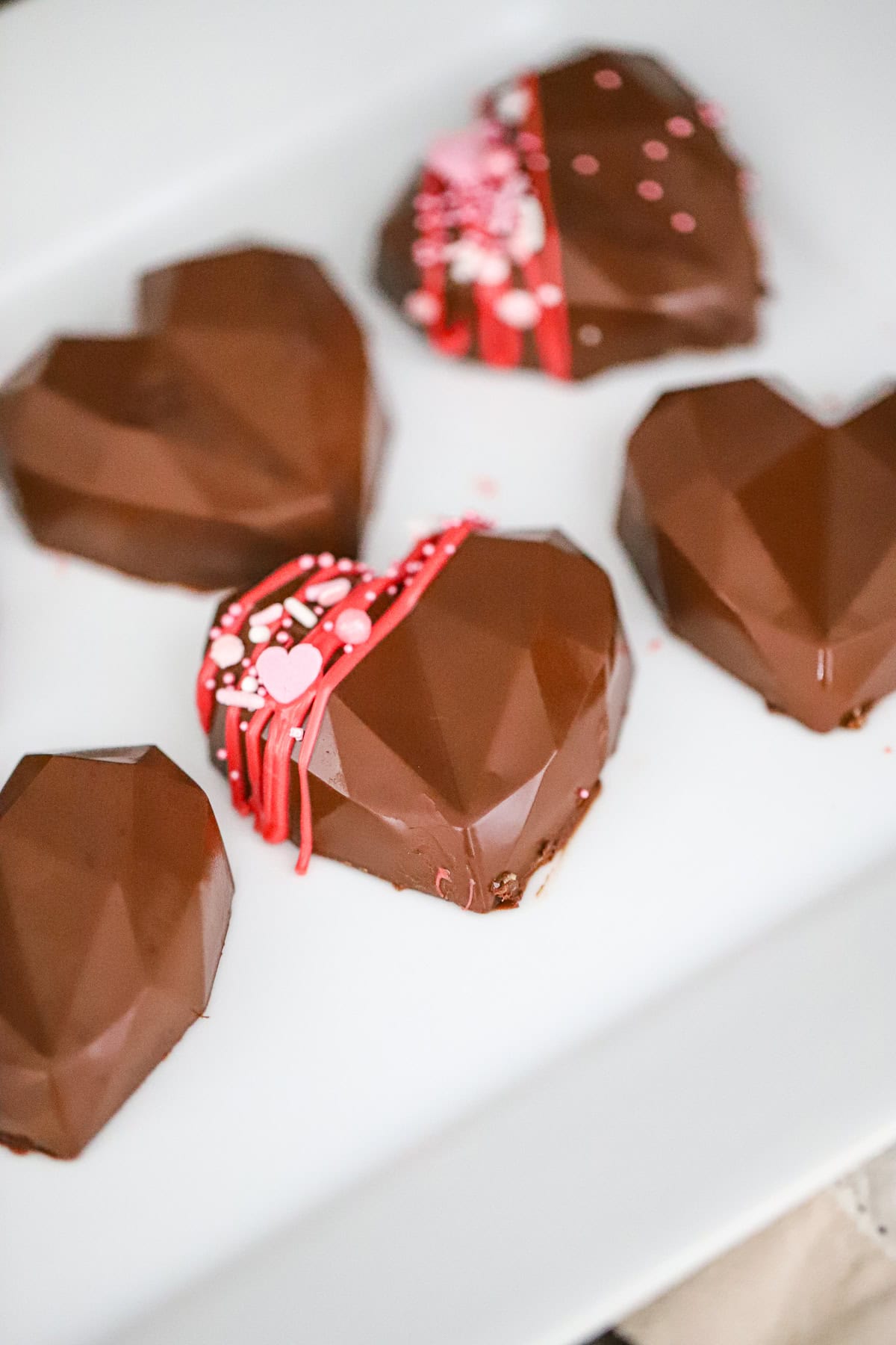 Close-up of homemade chocolate peanut butter hearts showing the glossy chocolate finish