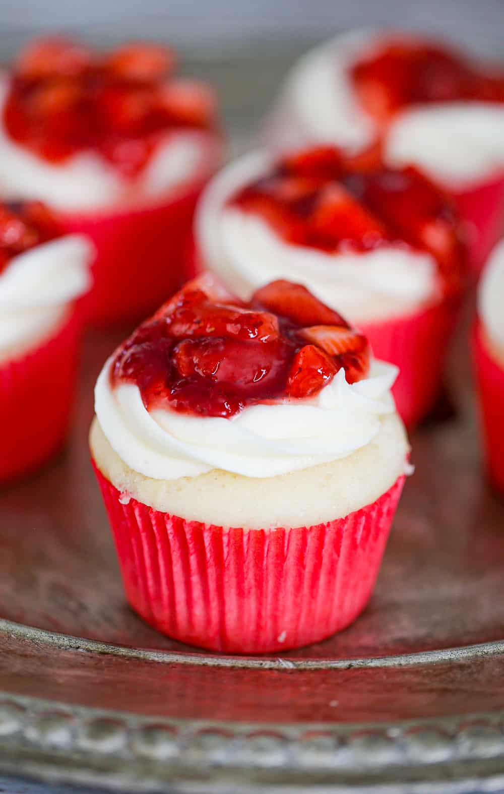 Strawberry Shortcake Cupcakes are vanilla cakes filled with light and fluffy whipped cream and finished with cream cheese frosting and fruity strawberry filling on top. 